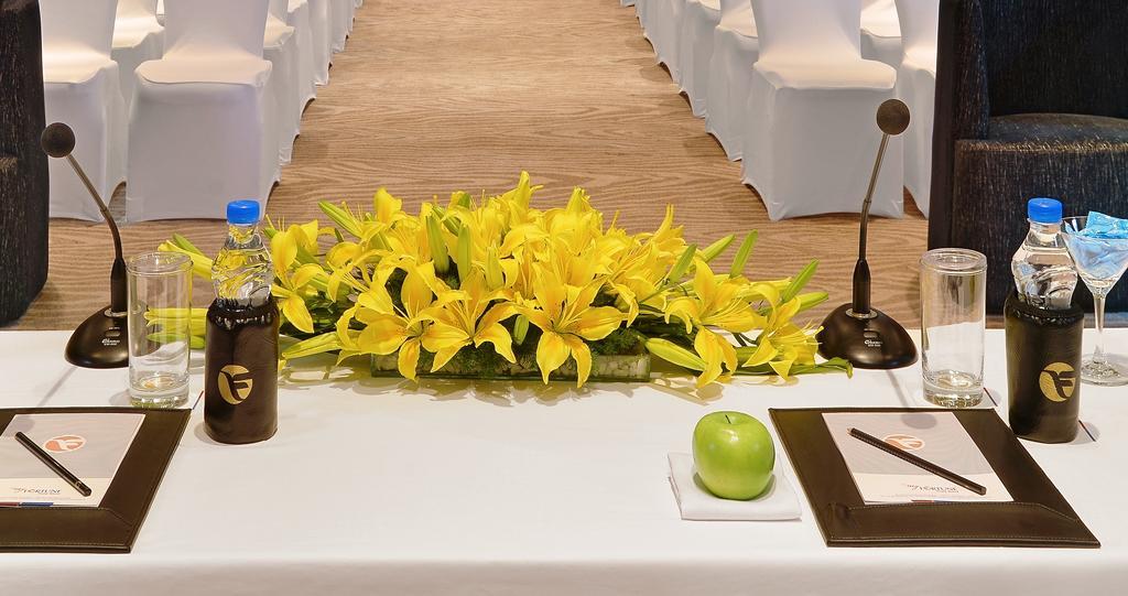 Welcomhotel By Itc Hotels, Richmond Road, Bengaluru Exterior foto A table with a microphone, a bottle of water, a green apple and a flower arrangement